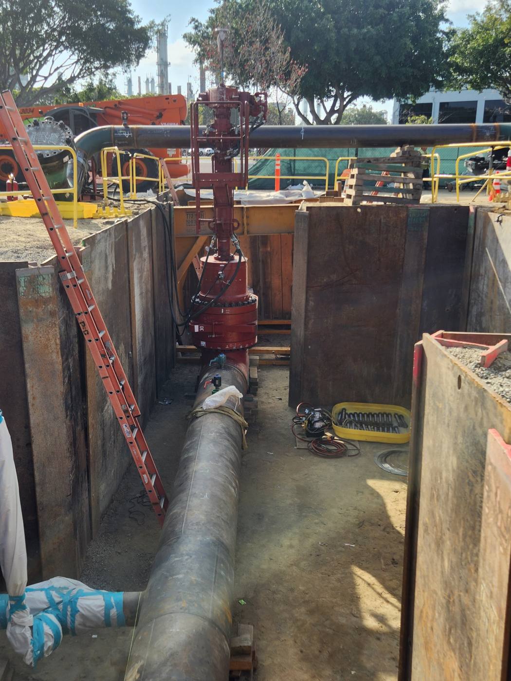 Large valve being installed in a shored pipeline trench
